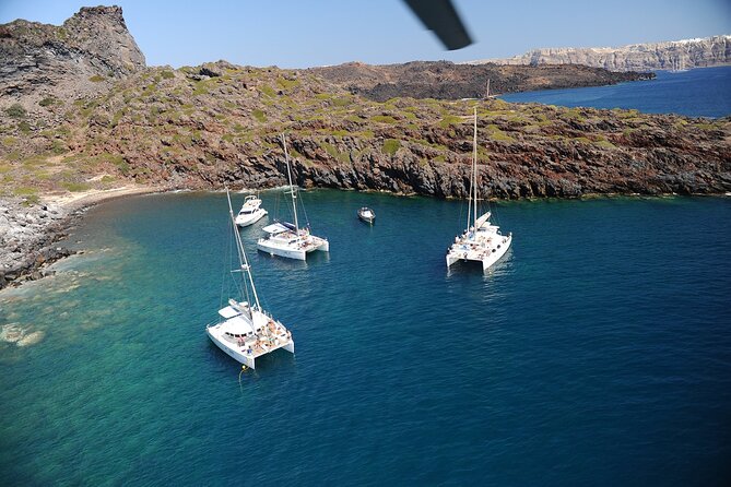 Santorini Classic Catamaran Cruise with BBQ, Drinks and Transfers - Sailing past volcano scenery: what the crew explains while you watch