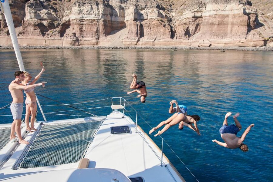 Santorini Gold Catamaran Cruise with Snorkel, BBQ & Open Bar - Stop 1, Red Beach: the first swim in Santorini’s signature cliffs