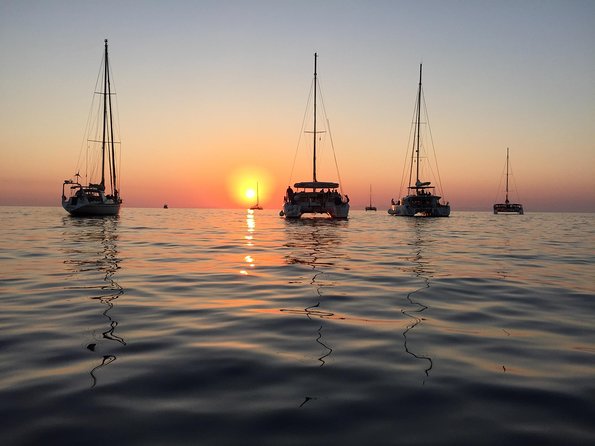 Santorini Luxury Catamaran Sunset Cruise with BBQ, Drink and Transfer - Volcano Sails and a Lighthouse View From Sea