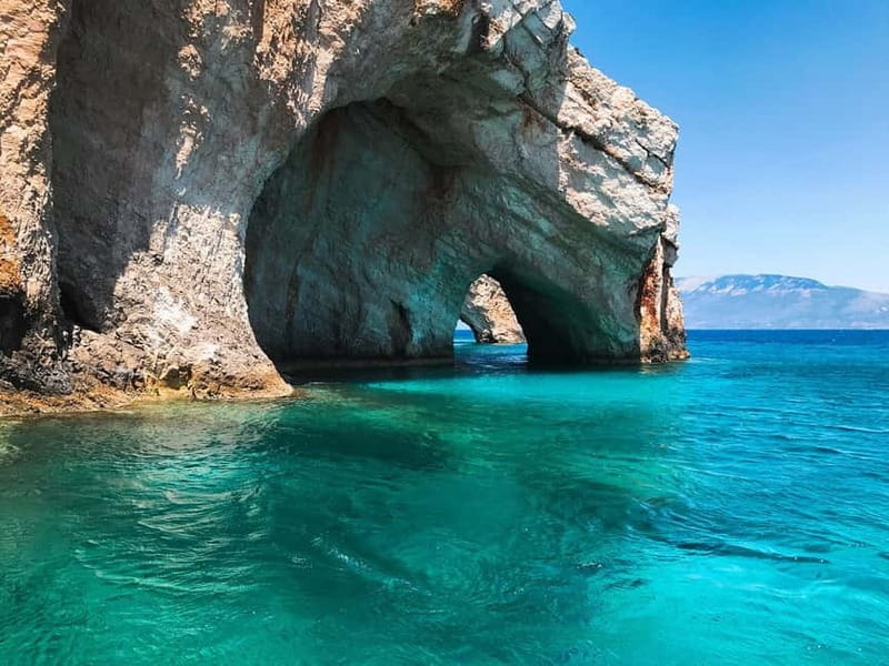 Zakynthos: Blue Caves and Navagio Bay Swim Cruise - Cruising past natural arches and old monastery ruins